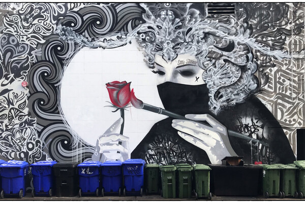 Graffiti of a masked woman painting a rose (Credit: Rowell Soller, Flips and Kreecha; located at Spadina and Cameron in Toronto)