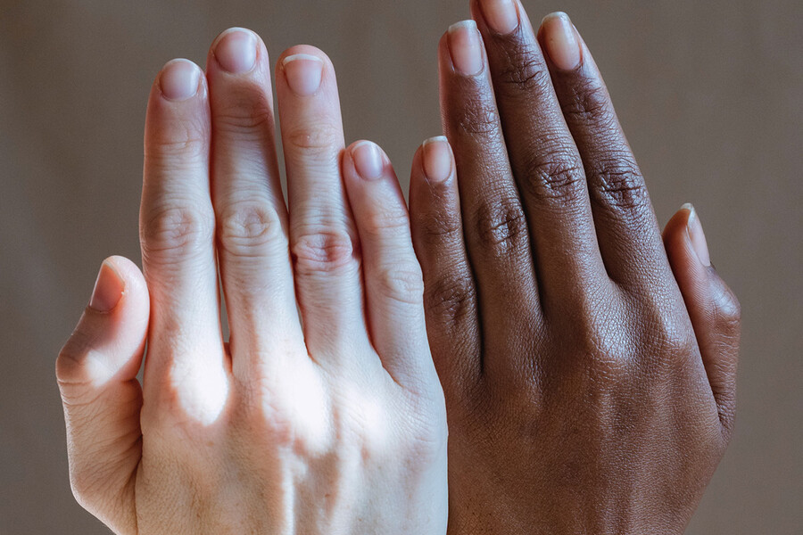 Two upheld hands with varying skintones