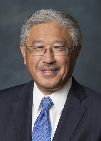 Portrait of Dr. Victor Dzau, smiling in front of grey background.