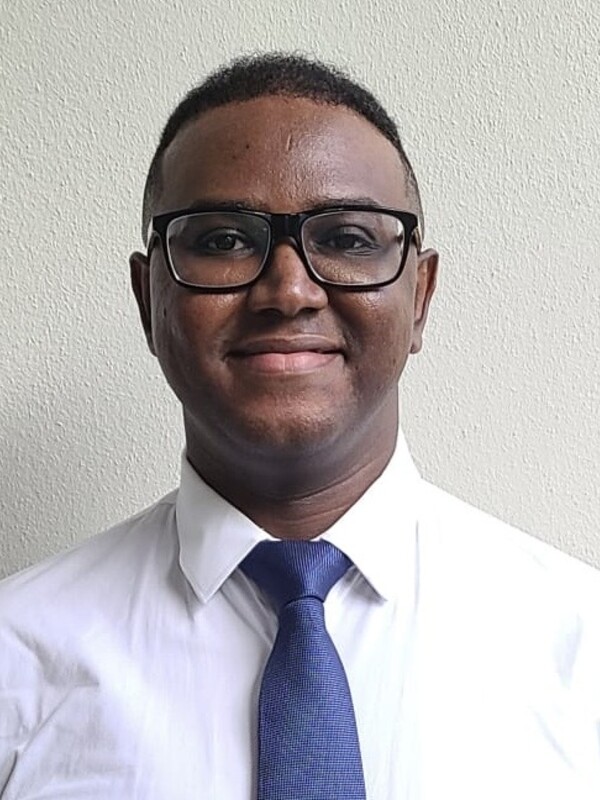 Black man wearing black frame glasses, shirt and tie