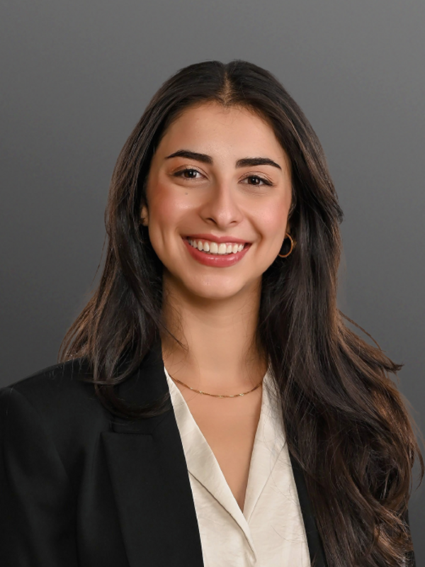 woman with light brown skin and long brown hair smiling