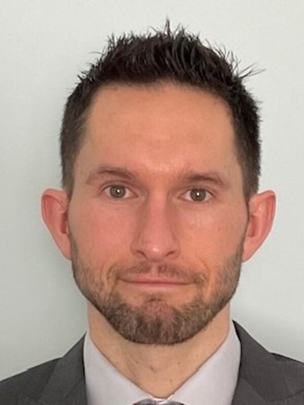 white man with short dark hair and short beard and mustache