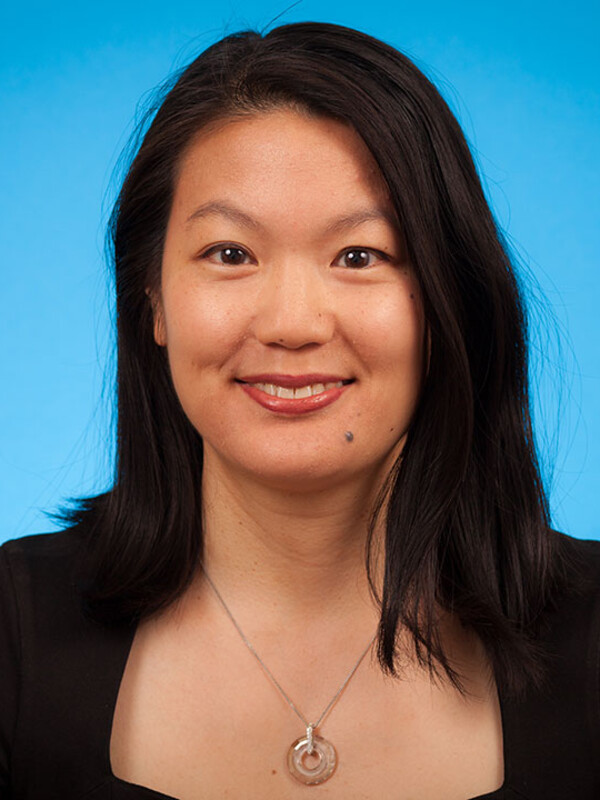 professional headshot of Dr. Catherine Yu, blue background, smiling at the camera