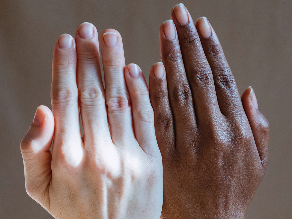 Two upheld hands with varying skintones